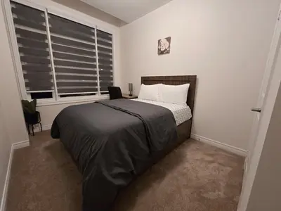 a bedroom with a bed and a window at Elegant 3BR Kleinburg Townhouse Free Parking Wifi Full Kitchen Laundry Near Canadas Wonderland in Vaughan