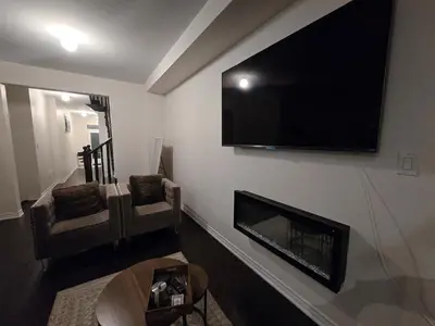a living room with a fireplace and a flat screen tv at Elegant 3BR Kleinburg Townhouse Free Parking Wifi Full Kitchen Laundry Near Canadas Wonderland in Vaughan