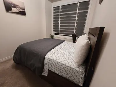 a small bedroom with a bed and a window at Elegant 3BR Kleinburg Townhouse Free Parking Wifi Full Kitchen Laundry Near Canadas Wonderland in Vaughan