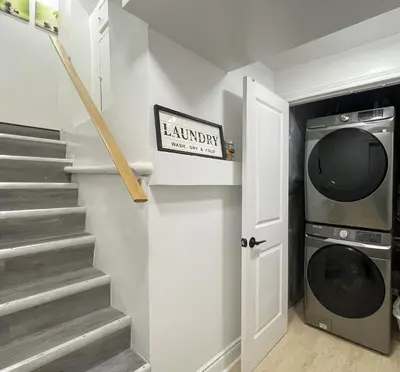 a laundry room with a washer and dryer at The Scholar Suite Modern Comfort Near Western U in London