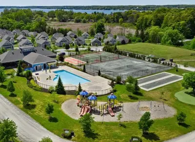 an aerial view of a resort with a pool and a tennis court at The Magnolia - 37 Butternut in Cherry Valley