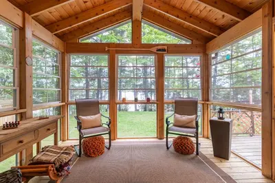 two chairs in a screened in porch with windows at Rustic and Spacious Lakefront Oasis in Nature in Algonquin Highlands