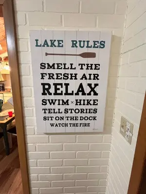 a sign on a brick wall with the words take rules smell the fresh air return at Rustic and Spacious Lakefront Oasis in Nature in Algonquin Highlands