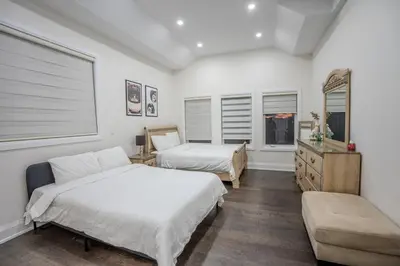 a bedroom with two beds and a dresser and windows at Perfect Group Getaway Large House with Style in Bolton
