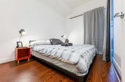 a bedroom with a bed with a night stand and a window at Luxury 1BR Plus Den Condo With Sauna Access in Toronto