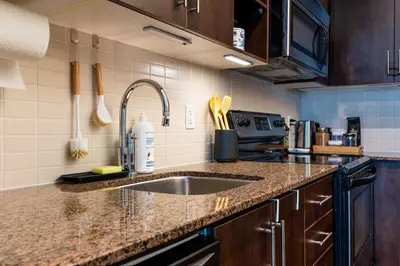 a kitchen with a sink and a counter top at Luxury 1BR Plus Den Condo With Sauna Access in Toronto