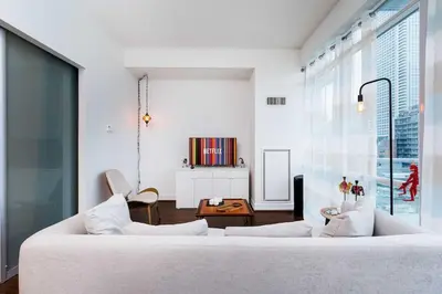 a living room with a white couch and a table at Luxury 1BR Plus Den Condo With Sauna Access in Toronto