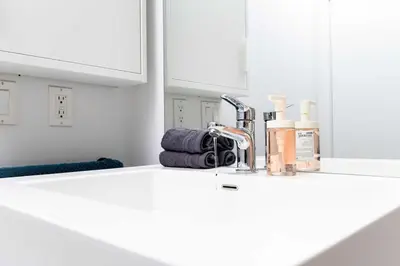 a white kitchen counter with a sink in a bathroom at Luxury 1BR Plus Den Condo With Sauna Access in Toronto