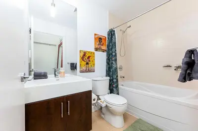 a bathroom with a sink and a toilet and a tub at Luxury 1BR Plus Den Condo With Sauna Access in Toronto