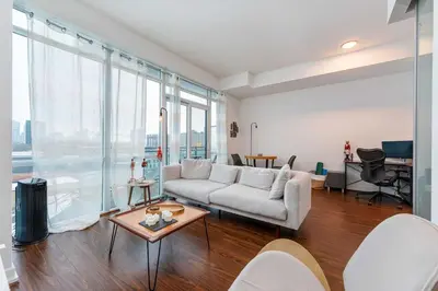 a living room with a couch and a table at Luxury 1BR Plus Den Condo With Sauna Access in Toronto