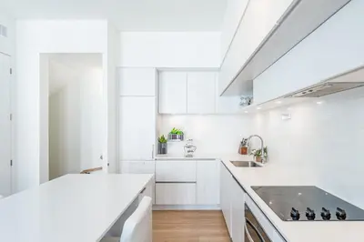 a white kitchen with a sink and a stove at Modern Family Townhouse 2 Bedrooms 3 Full Bathrooms Sleeps 6 in Richmond Hill
