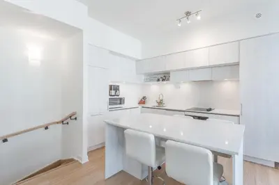 a white kitchen with a white table and chairs at Modern Family Townhouse 2 Bedrooms 3 Full Bathrooms Sleeps 6 in Richmond Hill