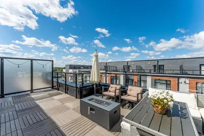 a balcony with a patio furniture and an umbrella at Modern Family Townhouse 2 Bedrooms 3 Full Bathrooms Sleeps 6 in Richmond Hill