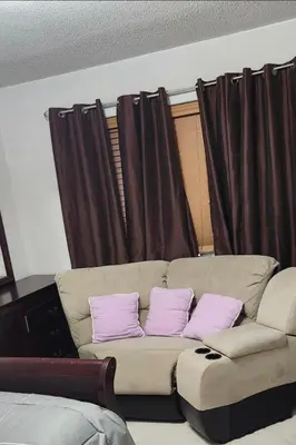a living room with a couch with two purple pillows at Beautiful Master bedroom with private 5PC ensuite washroom in Mississauga