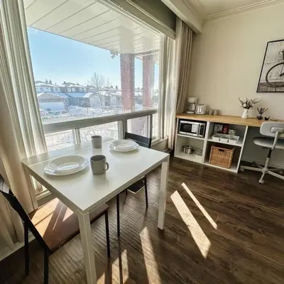 a living room with a table and a large window at Cozy Studio with 2 Beds & Private Bathroom in Toronto