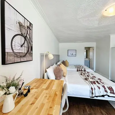 a bedroom with a large bed and a wooden table at Cozy Studio with 2 Beds & Private Bathroom in Toronto