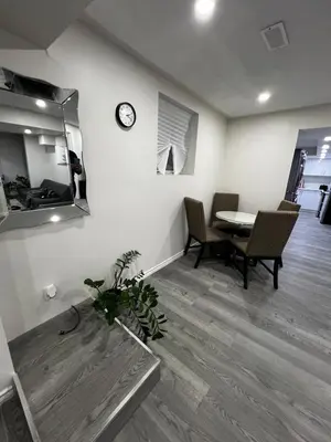 a living room with a table and a clock on the wall at Beautiful Newly Built 2 Bedrooms Basement Apartment in Milton ,Sleeps 6 in Milton