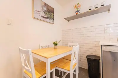 a kitchen with a wooden table and chairs at 2min to DT, Cowboys, Full-Kitchen, 65 inch TV in London