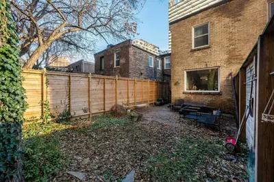 a backyard with a wooden fence next to a house at Spacious 3 Bedroom Toronto Home with Piano in Toronto