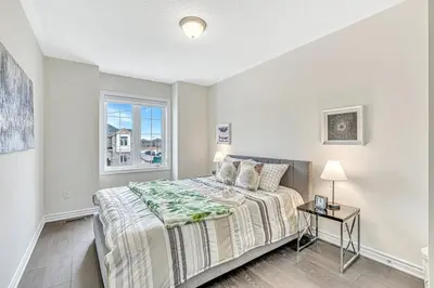 a bedroom with a large bed and a window at Spacious 3BR House with Modern Comforts in Thorold