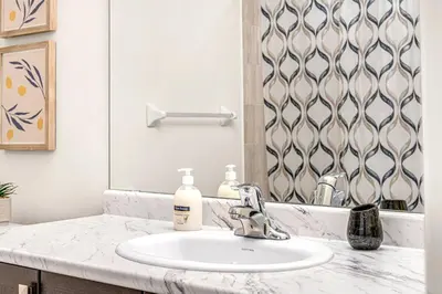 a bathroom with a sink and a mirror at Spacious 3BR House with Modern Comforts in Thorold