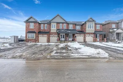 a large brick house with snow in front of it at Spacious 3BR House with Modern Comforts in Thorold