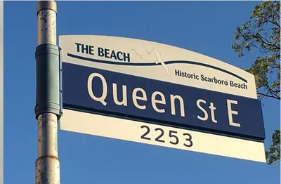 a street sign for queen street on a pole at Private Suite With Private Entrance - Entire Place in Toronto