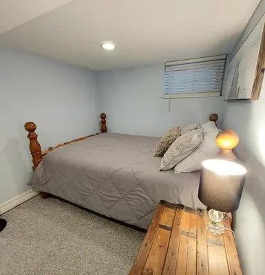 a bedroom with a bed and a table with a lamp at Private Suite With Private Entrance - Entire Place in Toronto