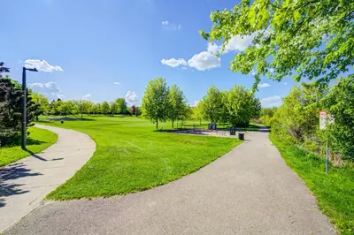 a walkway in a park with trees and grass at Lower-Level Classic House in Richmond Hill in Richmond Hill