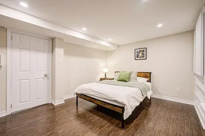 a bedroom with a bed and a white wall at Lower-Level Classic House in Richmond Hill in Richmond Hill