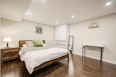 a bedroom with a large bed and a table at Lower-Level Classic House in Richmond Hill in Richmond Hill