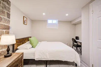 a bedroom with a bed and a table with a lamp at Lower-Level Classic House in Richmond Hill in Richmond Hill
