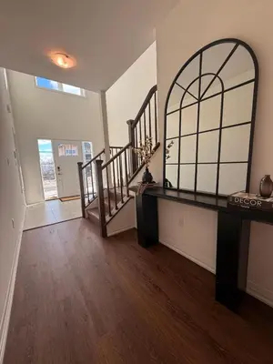 a living room with a staircase and a mirror at Serene Escape Near Niagara Falls - Premium in Thorold