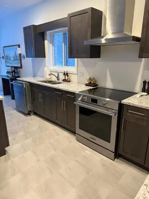 a kitchen with brown cabinets and a sink and a stove at Serene Escape Near Niagara Falls - Premium in Thorold
