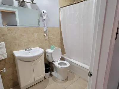 a bathroom with a toilet and a sink and a shower at Cobourg Inn in Cobourg