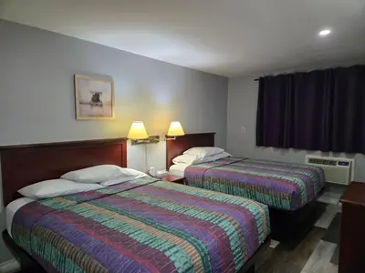 a hotel room with two beds and a window at Cobourg Inn in Cobourg