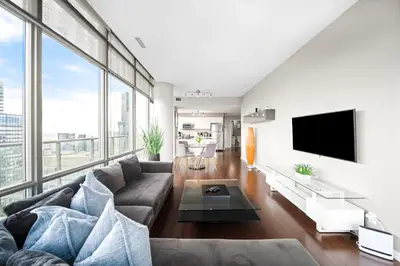 a living room with a couch and a tv at Lux Penthouse Retreat Near Yorkville with Parking in Toronto