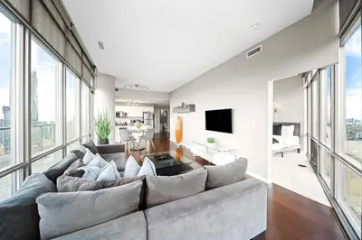 a living room with a large couch and large windows at Lux Penthouse Retreat Near Yorkville with Parking in Toronto