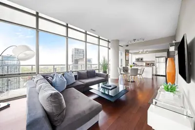 a living room with a couch and a table at Lux Penthouse Retreat Near Yorkville with Parking in Toronto