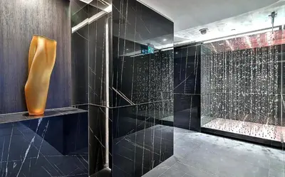 a bathroom with a shower with black tiles at Stylish Yorkville Condo Sleeps 3 Prime Location in Toronto