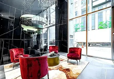 a room with red chairs and a table in a building at Stylish Yorkville Condo Sleeps 3 Prime Location in Toronto