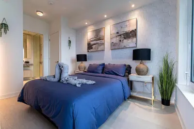 a bedroom with two beds with blue sheets at Luxury Yorkville Two Bedroom Condo With Views and Parking in Toronto