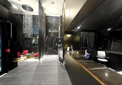 a woman sitting at a counter in a bathroom at Luxury Yorkville Two Bedroom Condo With Views and Parking in Toronto