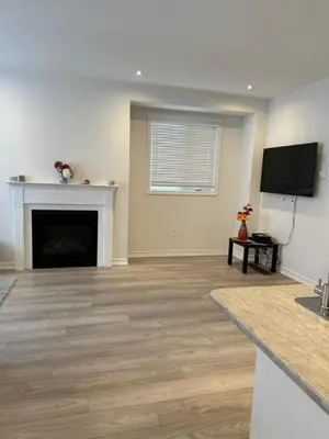 a living room with a fireplace and a flat screen tv at Charming Short-Term Stay Near Downtown Fergus & Elora Mill in Fergus