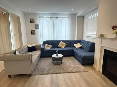 a living room with a blue couch and a fireplace at Charming Short-Term Stay Near Downtown Fergus & Elora Mill in Fergus