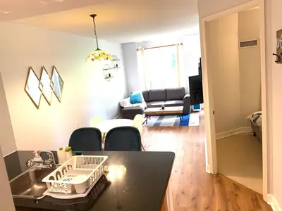 a kitchen and living room with a table and chairs at Bloor Yonge Cozy 1BR And Den Free Parking in Toronto
