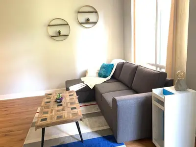a living room with a couch and a table at Bloor Yonge Cozy 1BR And Den Free Parking in Toronto