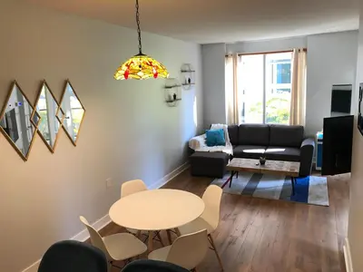 a living room with a table and a couch at Bloor Yonge Cozy 1BR And Den Free Parking in Toronto