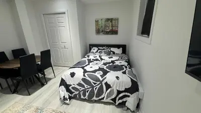 a bedroom with a bed with a black and white comforter at Cozy Studio Retreat in Scenic Georgina, Canada in Georgina