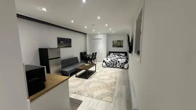 a bedroom with a bed and a living room at Cozy Studio Retreat in Scenic Georgina, Canada in Georgina